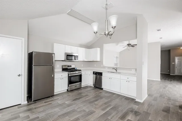 a kitchen with stainless steel appliances granite countertop a refrigerator a stove a sink and a refrigerator