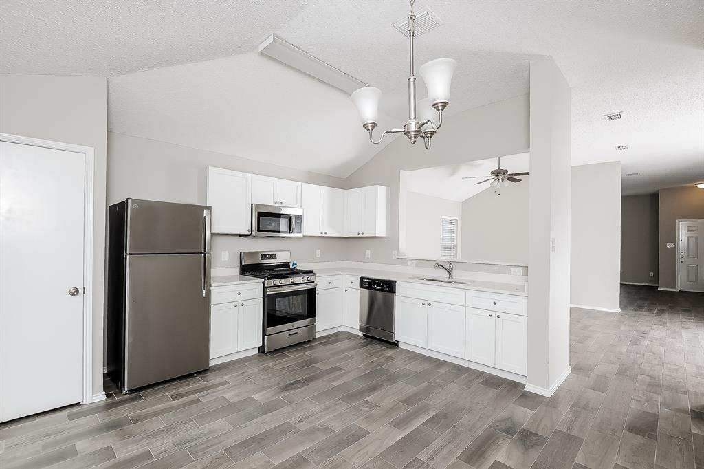 7417 Snow Ridge Drive Fort Worth, TX 76133 - Photo 7 of 16 a kitchen with stainless steel appliances granite countertop a refrigerator a stove a sink and a refrigerator