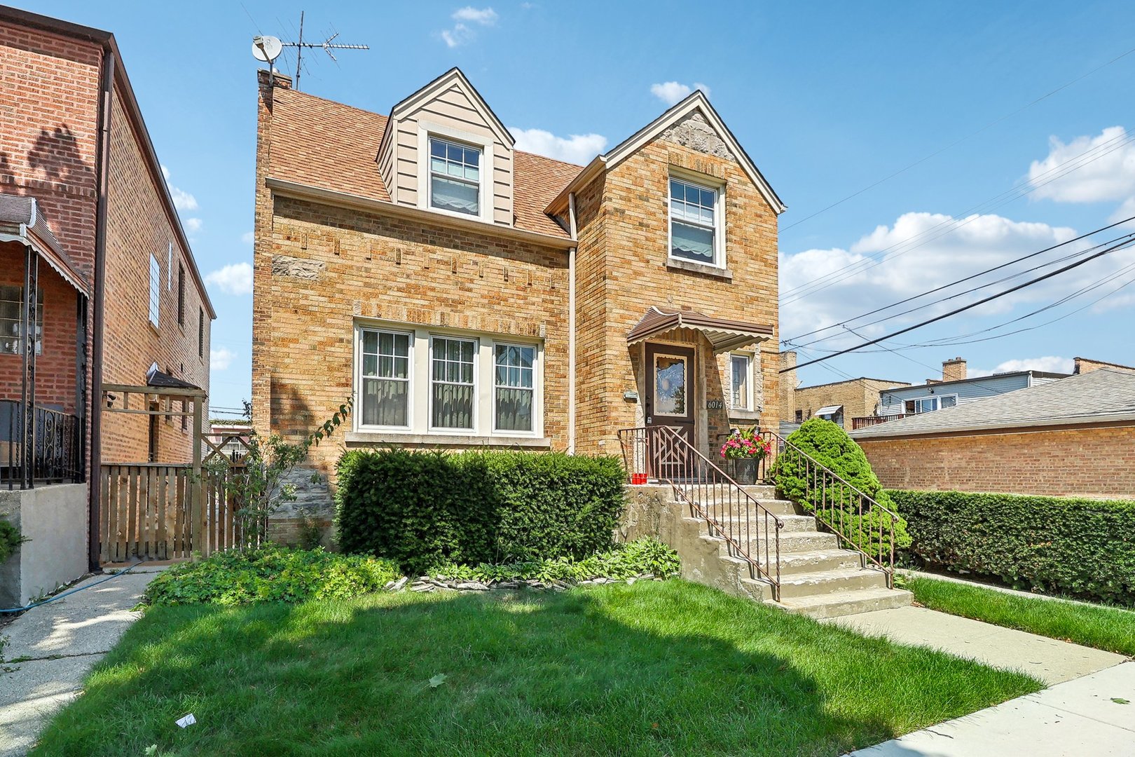 6014 West Fletcher Street Chicago, IL 60634 - Photo 2 of 28 a view of a brick house with a large windows and a yard with plants and large trees