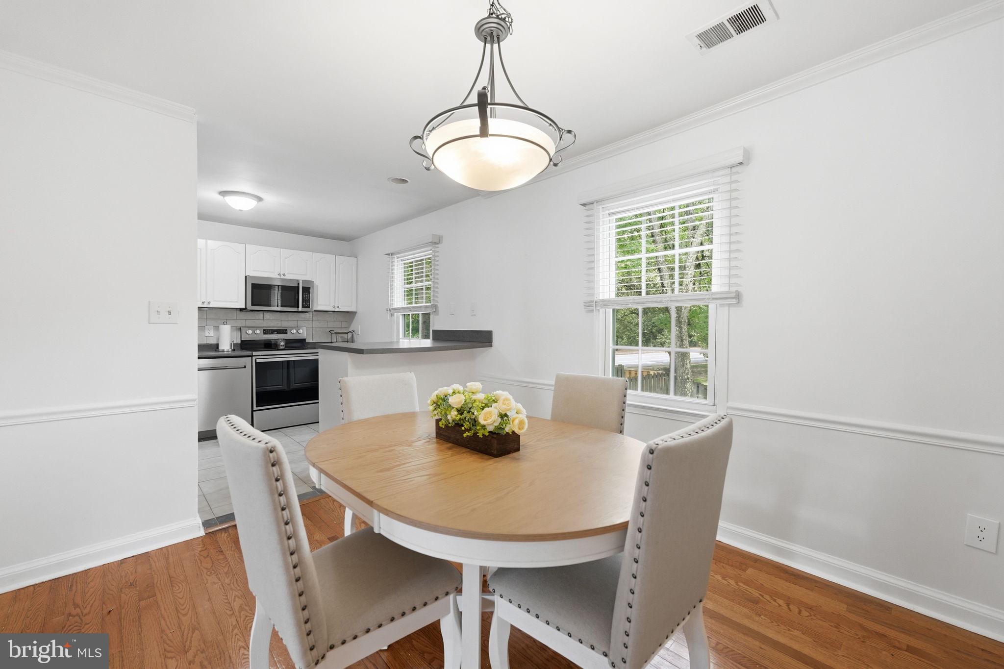 8260 Getty Court Springfield, VA 22153 - Photo 10 of 31 a view of a dining room with furniture window and wooden floor