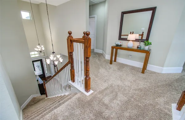 a view of a hallway to room with wooden floor and stairs