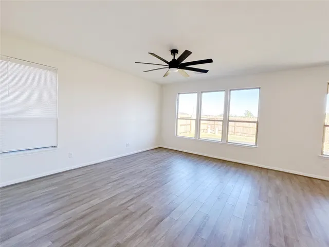 a large open kitchen with kitchen island a sink wooden floor and a large window