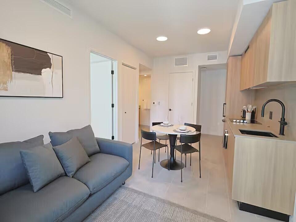 121 Northeast 5th Street Miami, FL 33132 - Photo 3 of 26 a living room with furniture a refrigerator and wooden floor