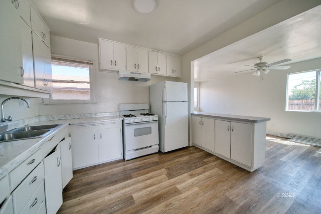137 South Richmond Road Ridgecrest, CA 93555 - Photo 9 of 31 a kitchen with cabinets wooden floor and stainless steel appliances