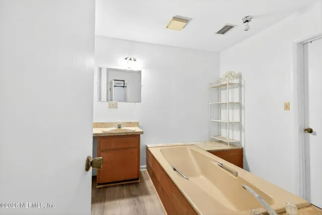 a bathroom with a tub sink and mirror