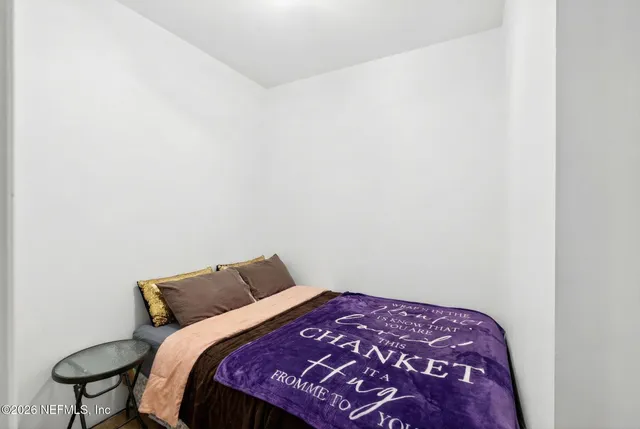 a bedroom with a bed and a window