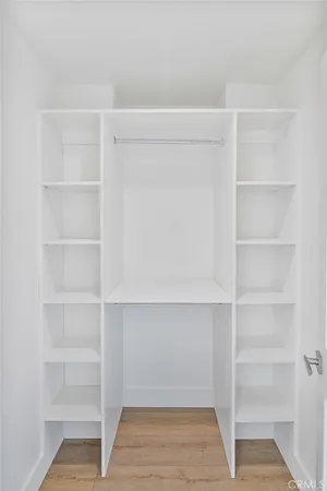 an empty room with chandelier fan and windows