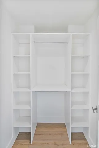 an empty room with chandelier fan and windows