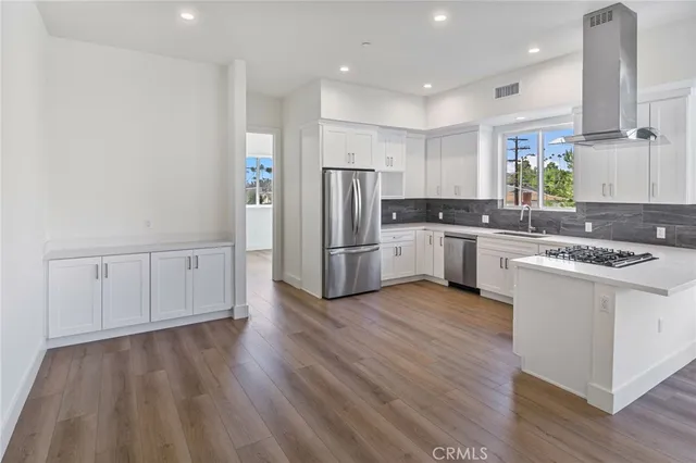 a kitchen with white cabinets sink and stainless steel appliances