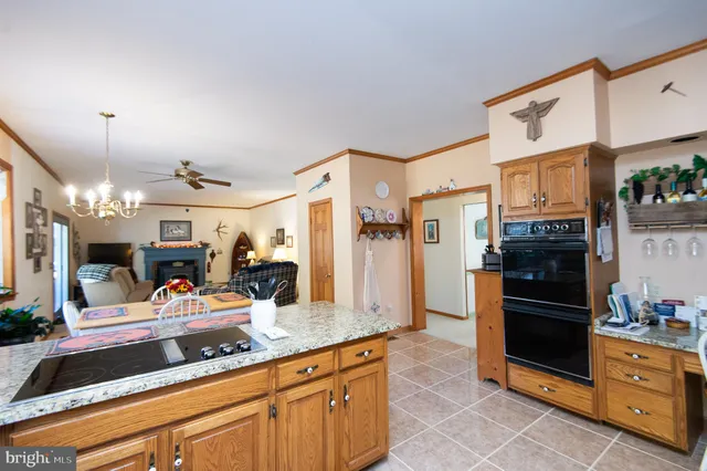 a kitchen with stainless steel appliances kitchen island granite countertop a refrigerator and a stove top oven