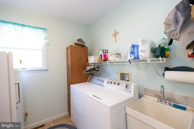 a utility room with sink dryer and washer