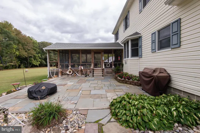 a view of a patio with table and chairs potted plants and a large tree