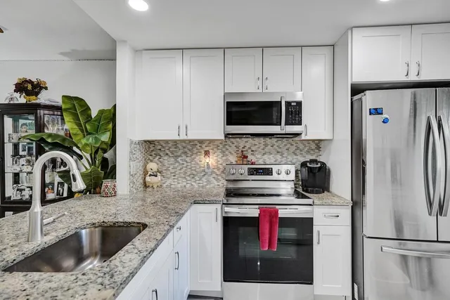 a kitchen with refrigerator a microwave and sink