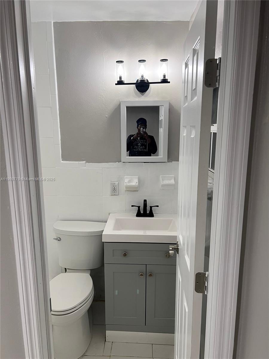 417 Southwest 8th Avenue Delray Beach, FL 33444 - Photo 16 of 18 a bathroom with a toilet sink and mirror