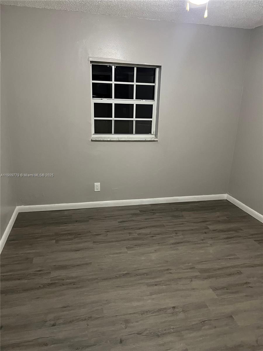 417 Southwest 8th Avenue Delray Beach, FL 33444 - Photo 6 of 18 a view of an empty room with wooden floor and windows