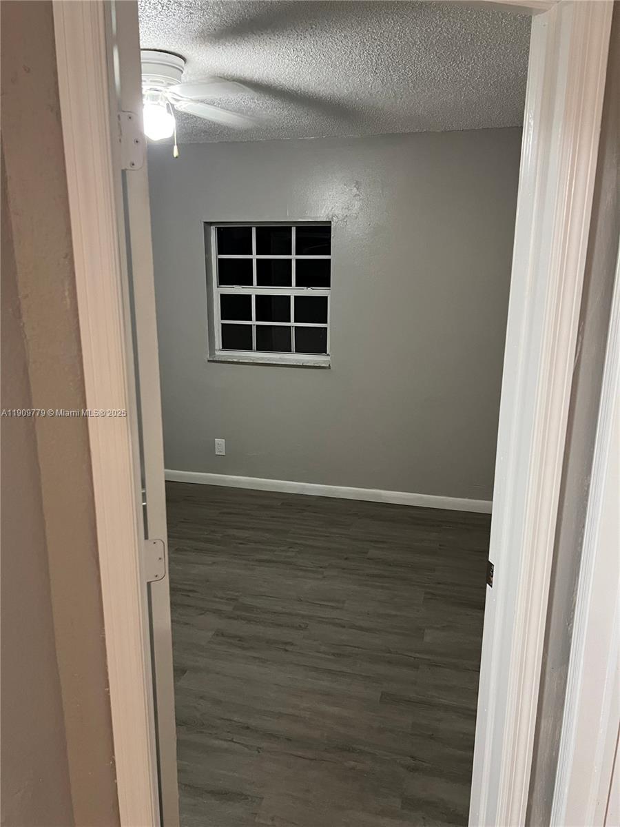 417 Southwest 8th Avenue Delray Beach, FL 33444 - Photo 7 of 18 a view of an empty room with wooden floor and a window