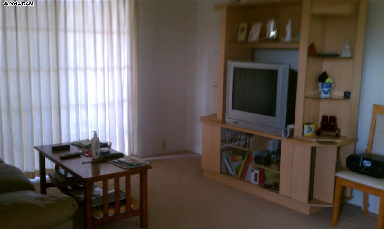 140 Uwapo Road, Unit 1201 Kihei, HI 96753 - Photo 1 of 8 a room with furniture and a flat screen tv
