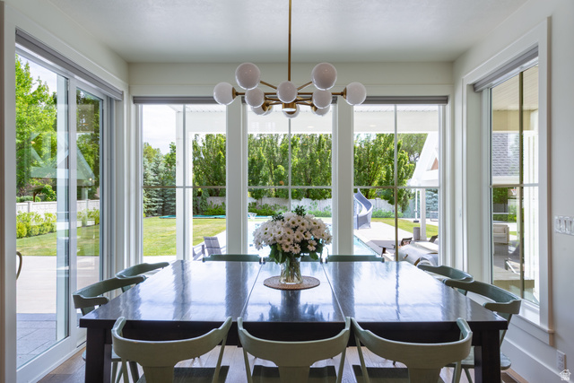 630 East Center Street Alpine, UT 84004 - Photo 30 of 115 Bright dining space featuring a contemporary chandelier with globe lights, expansive windows, multiple glass sliding doors, and wood-finish flooring