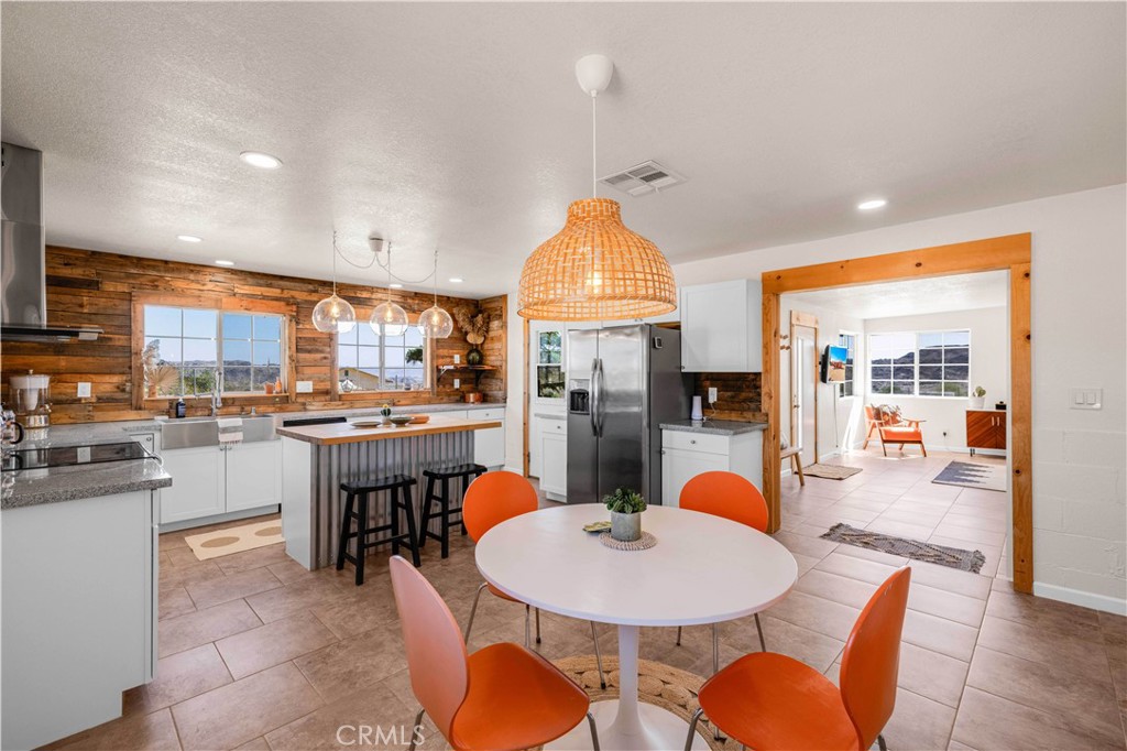 55850 Shannon Road Landers, CA 92285 - Photo 13 of 66 a dining room with stainless steel appliances kitchen island granite countertop a dining table chairs and view of living room