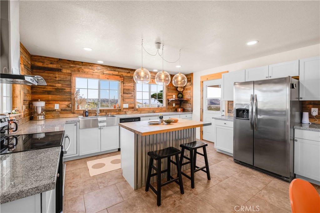 55850 Shannon Road Landers, CA 92285 - Photo 14 of 66 a kitchen with a refrigerator a sink dishwasher with a dining table and chairs