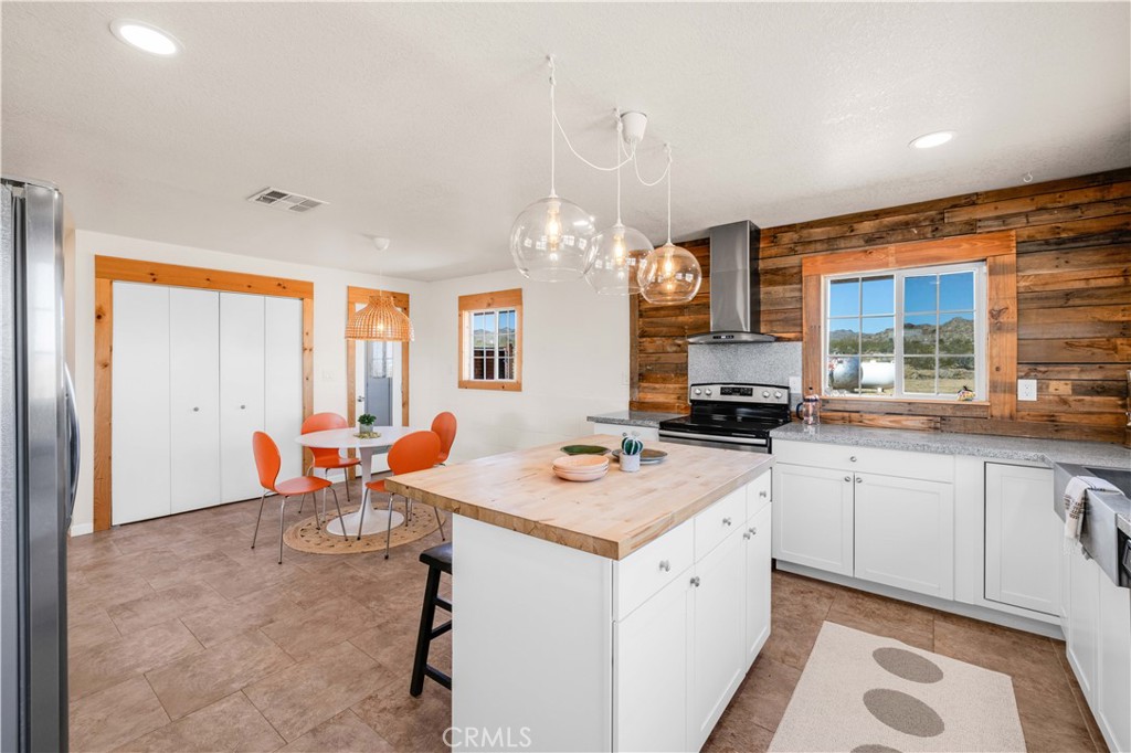 55850 Shannon Road Landers, CA 92285 - Photo 16 of 66 a large white kitchen with a sink and dishwasher a stove top oven with wooden floor