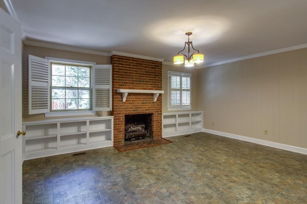 1501 Hillsboro Road Franklin, TN 37069 - Photo 12 of 24 an empty room with fireplace cabinet and windows