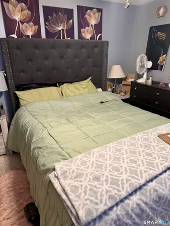 a bed sitting in a bedroom next to a lamp