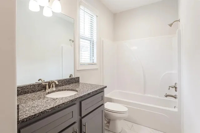 a bathroom with a granite countertop double sink and a mirror