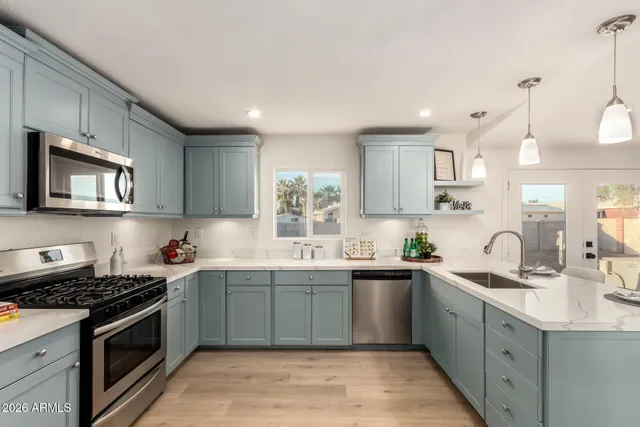 a kitchen with stainless steel appliances kitchen island granite countertop a sink and cabinets