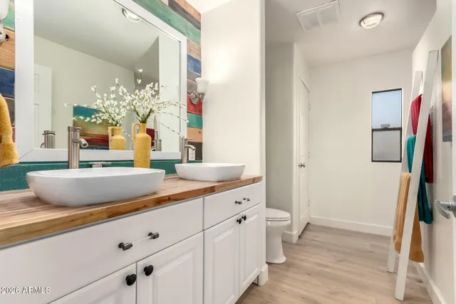 a bedroom with a bed and a large mirror next to a window