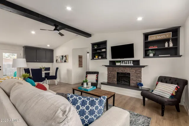 a living room with furniture a fireplace and a flat screen tv