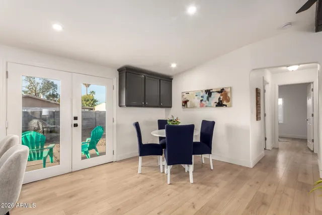 a dining room with furniture potted plants and wooden floor