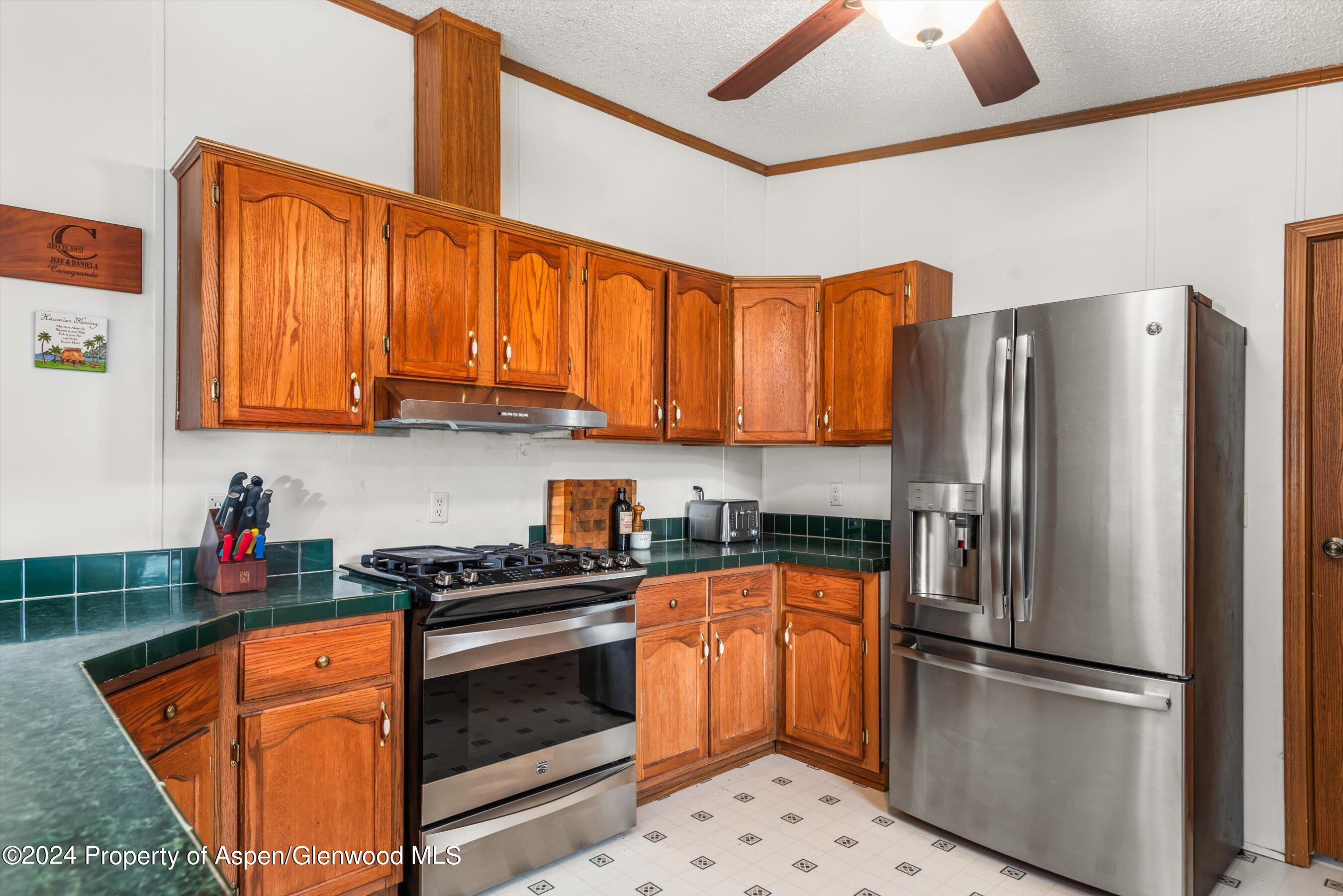 71 Nathan El Jebel, CO 81623 - Photo 4 of 29 a kitchen with stainless steel appliances granite countertop a refrigerator a stove a sink and dishwasher with wooden cabinets