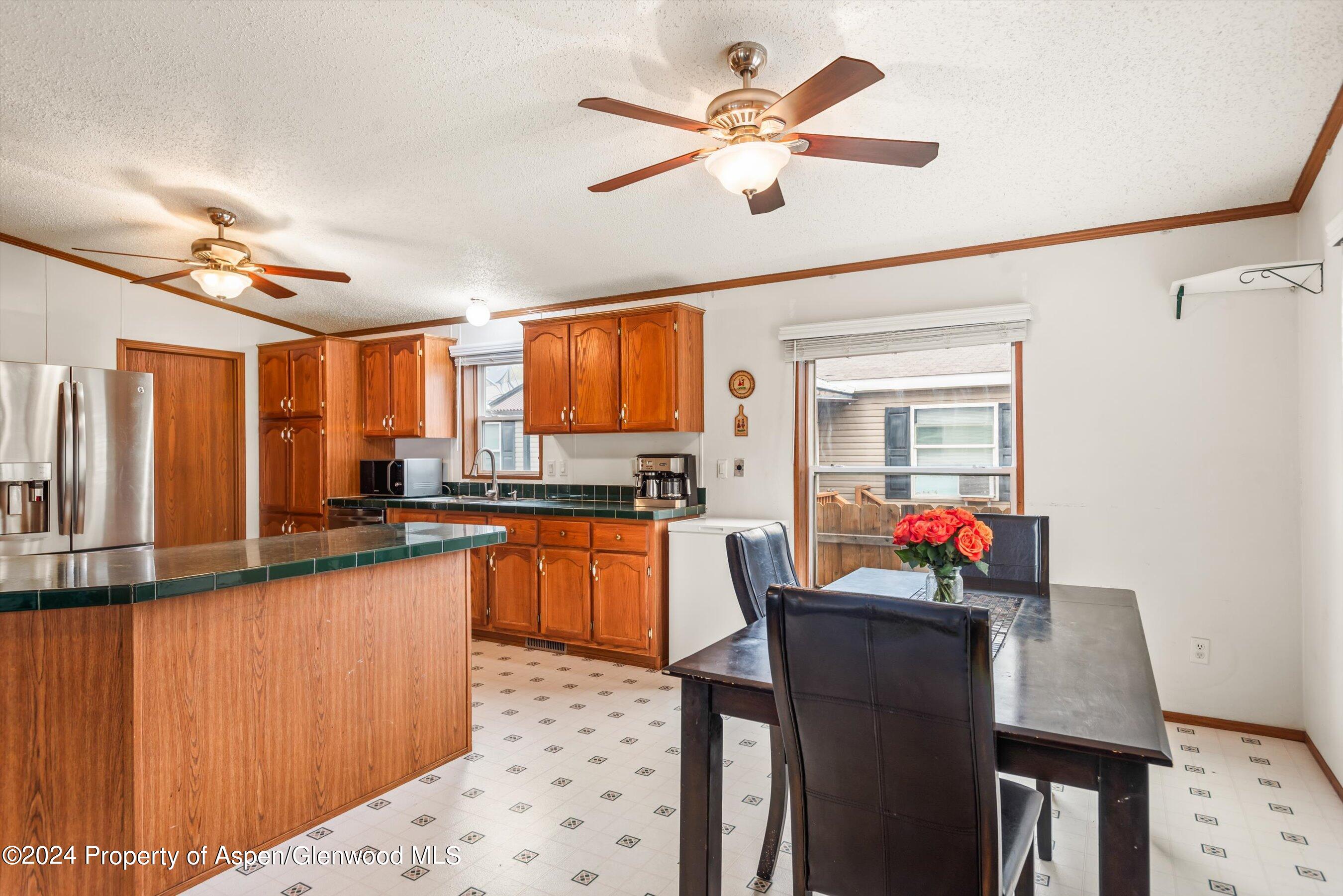 71 Nathan El Jebel, CO 81623 - Photo 8 of 29 a kitchen with stainless steel appliances kitchen island granite countertop a refrigerator a sink dishwasher a dining table and chairs with wooden floor