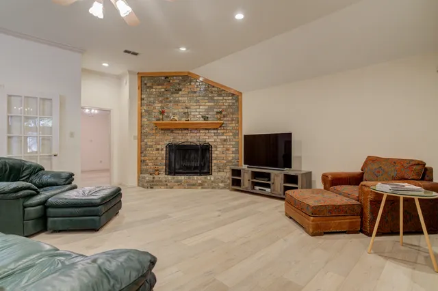 a living room with furniture a flat screen tv and a fireplace