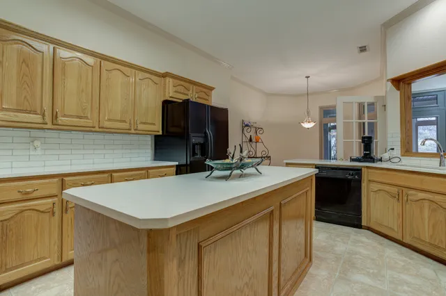 a kitchen with stainless steel appliances granite countertop a stove top oven a refrigerator a sink and dishwasher