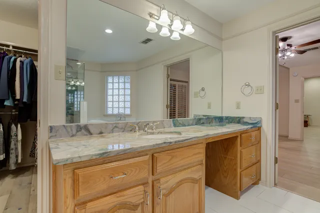 a spacious bathroom with a granite countertop sink mirror and bathtub