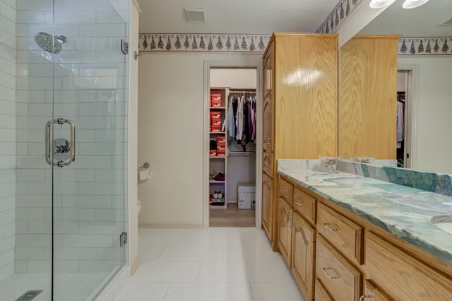 a bathroom with a granite countertop sink a mirror and shower