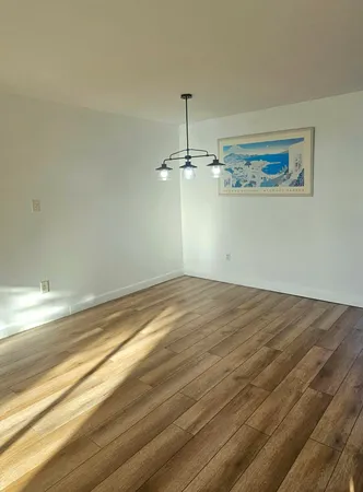 a view of a room with wooden floor and ceiling fan