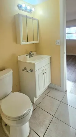 a bathroom with a toilet sink and mirror