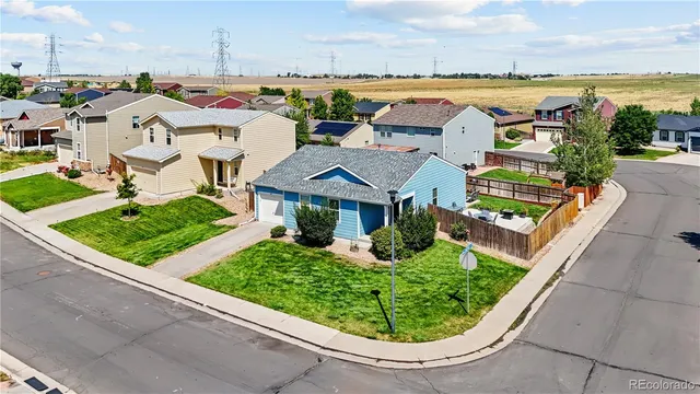 an aerial view of residential houses with outdoor space and ocean view