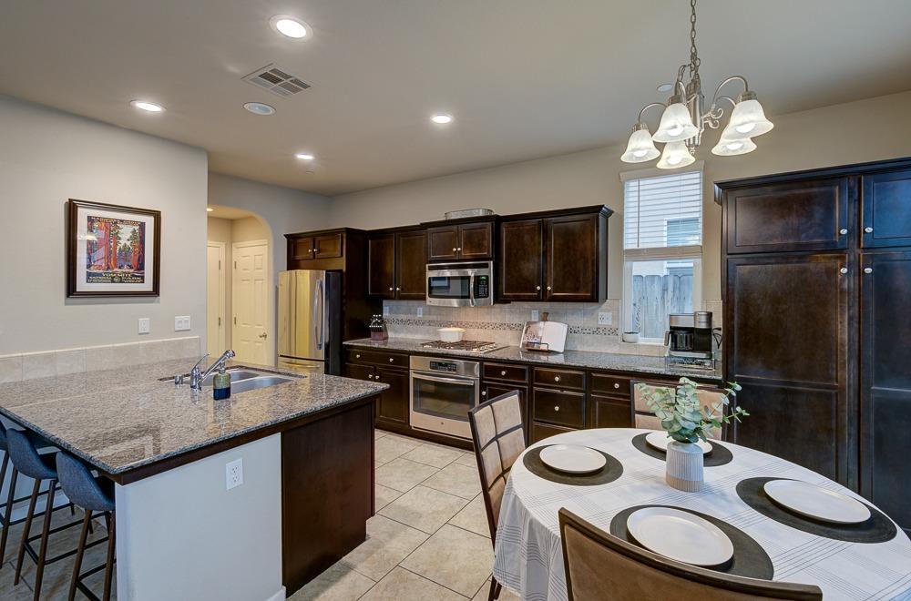 3518 Significant Way Clovis, CA 93619 - Photo 6 of 34 a kitchen with a sink a stove and chairs