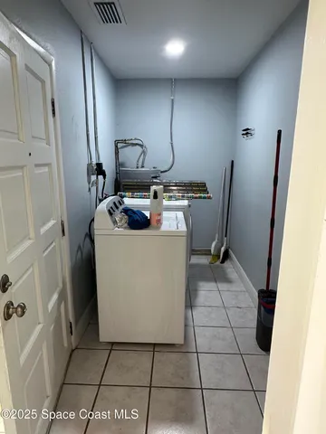 a room with a washing machine and cabinets