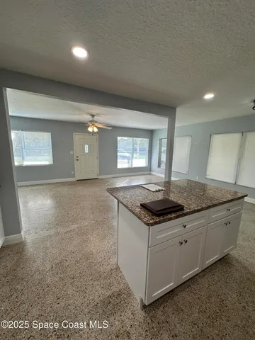 a kitchen with granite countertop a sink and a stove