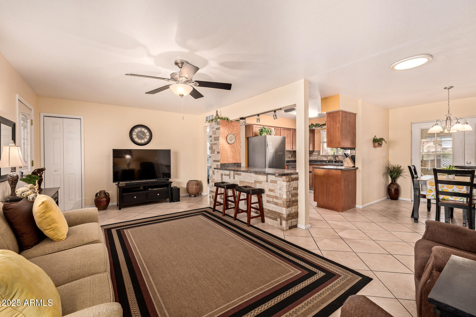 5501 East Adobe Road Mesa, AZ 85205 - Photo 5 of 38 a living room with furniture a flat screen tv and kitchen view