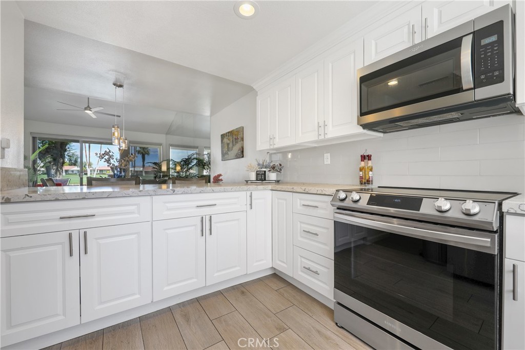 74 Avenida Las Palmas Rancho Mirage, CA 92270 - Photo 8 of 23 a kitchen with white cabinets stainless steel appliances and sink