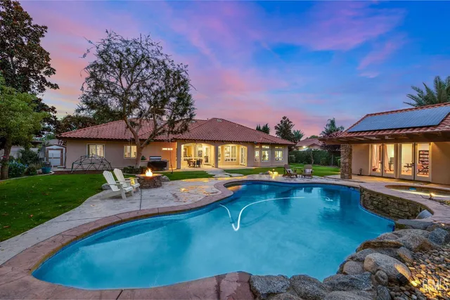 an aerial view of residential houses with outdoor space and trees