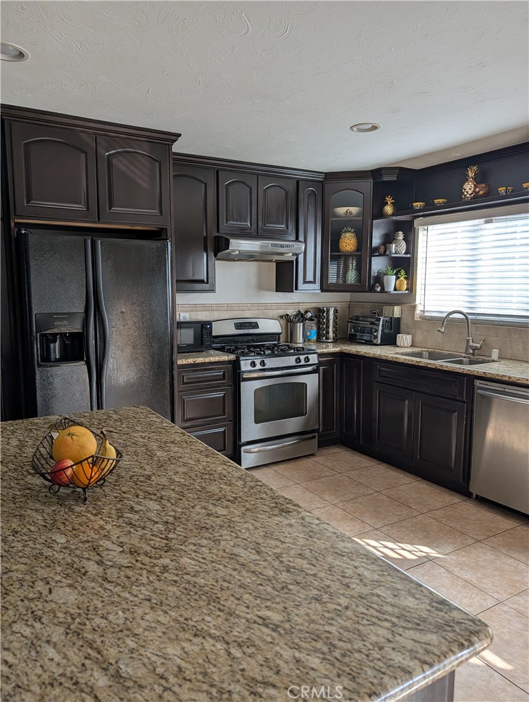 8394 Comet Street Rancho Cucamonga, CA 91730 - Photo 20 of 39 a kitchen with stainless steel appliances granite countertop a stove sink and cabinets