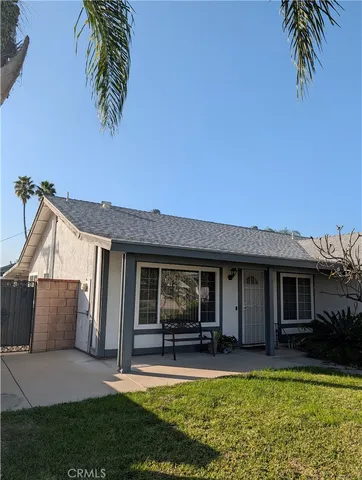 a view of a house with a yard potted plants and a large tree
