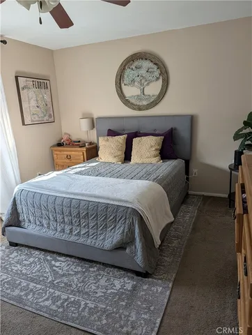 a bedroom with a bed and painting on the wall